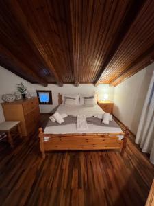 VergiaPalm Nest Villa with private pool in Chalkidiki的卧室里有一张大床，配有木质天花板 更多37张照片