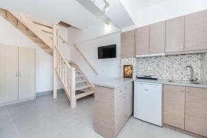 a kitchen with white cabinets and a staircase at Sea View Village in Vasilikos