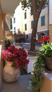 een groep bloemen op een binnenplaats met een gebouw bij Hotel Souvenir in Monterosso al Mare