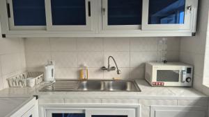a kitchen with a sink and a microwave at Appartement moderne avec balcon in Lomé