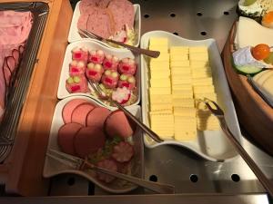 a tray of cheese and other food on a table at Haus am Meer, Hotel Garni in Helgoland