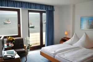 a hotel room with a bed and a view of the ocean at Haus am Meer, Hotel Garni in Helgoland