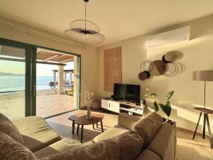a living room with a couch and a television at Villa Penelope Spartia Kefalonia in Spartià