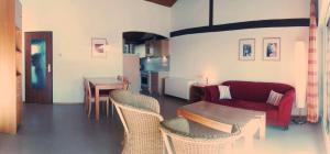a living room with a couch and a table and chairs at Ferienhaus Gamssteige im Feriendorf Reichenbach G25b in Nesselwang +5 photos