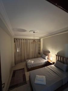 a hotel room with two beds and a window at Appartement Mendoubia in Tangier