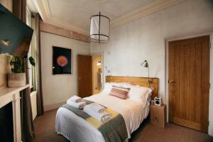 1 dormitorio con 1 cama con toallas en The Culpeper Bedrooms, en Londres