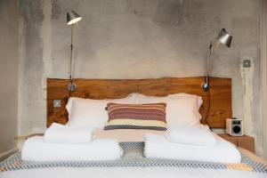a bed with two lamps on top of it at The Culpeper Bedrooms in London