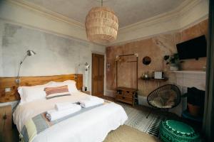 a bedroom with a bed and a chandelier at The Culpeper Bedrooms in London