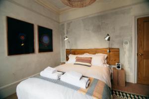 a bedroom with a bed with towels on it at The Culpeper Bedrooms in London