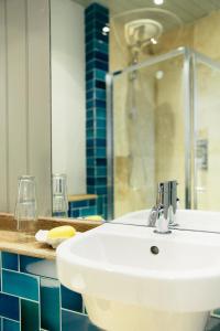 a bathroom with a sink and a shower at The Culpeper Bedrooms in London