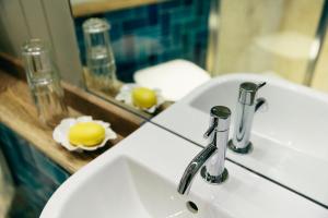 a white bathroom sink with a mirror and a sink at The Culpeper Bedrooms in London