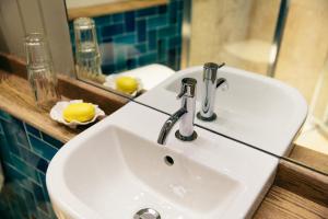 a white sink in a bathroom with a mirror at The Culpeper Bedrooms in London