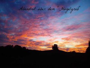 a sunset with the words island usan allegretto in the sky at Ferienwohnungen "Christelhof" in Wustrow