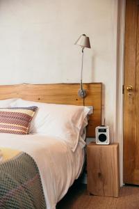 a bedroom with a bed with a clock on a night stand at The Culpeper Bedrooms in London