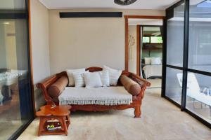 a living room with a couch with pillows on it at Alam Kesehatan Wellness retreat in Nimbin +1 photo