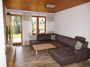 a living room with a brown couch and a table at Ferienhaus Fuchsweg im Feriendorf Reichenbach F29 in Nesselwang +8 photos