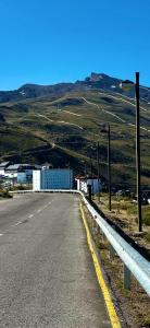 un camino vacío con luces de la calle a un lado de la carretera en estudio muy acogedor, en Sierra Nevada