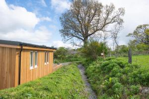 a house with a wooden fence next to a field at The Drey Inchberry 