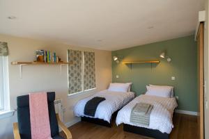 a bedroom with two beds and a chair at The Drey Inchberry  +12 photos