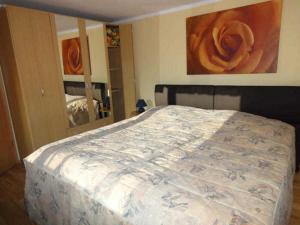 a bedroom with a large bed with a painting on the wall at Ferienhaus Grüner Winkel - Nähe Strandstraße in Müritz +5 photos