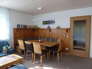 Un comedor con mesa y sillas de madera. en Ferienhaus Fuchsweg im Feriendorf Reichenbach F21, en Nesselwang