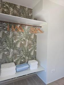 un armadio con asciugamani su uno scaffale con carta da parati di Frente al Mar Primera Linea de Playa Samil a Vigo Altre 24 foto