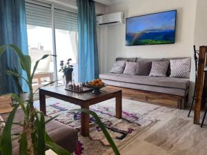 una sala de estar con un sofá y una mesa en Rooftop Terrasse - Centre Gueliz, en Marrakech