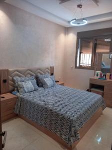a bedroom with a large bed with blue pillows at Tangier Beach Front in Tangier