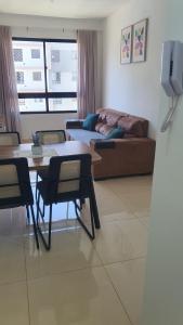 a living room with a table and chairs and a couch at Apto condomínio conforto e ótima localização in Lucas do Rio Verde