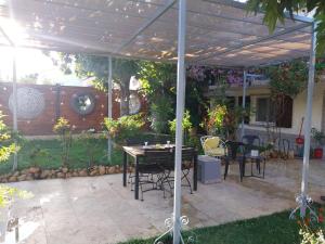 eine Terrasse mit Tisch und Stühlen unter einer Pergola in der Unterkunft Maison en rez-de chaussée près du centre ville d'Arles in Arles