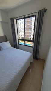 a bedroom with a bed and a large window at Apto condomínio conforto e ótima localização in Lucas do Rio Verde +23 photos