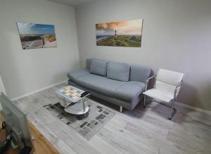 una sala de estar con un sofá y una silla en Ferienwohnung "Leuchtturm", en Ribnitz-Damgarten