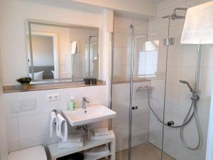 a white bathroom with a sink and a shower at Seestern 02 in Grömitz