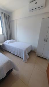 a bedroom with two beds and a window at Apto condomínio conforto e ótima localização in Lucas do Rio Verde