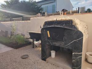 ein Steinofen in einem Hinterhof mit einer Spüle in der Unterkunft Maison en rez-de chaussée près du centre ville d'Arles in Arles