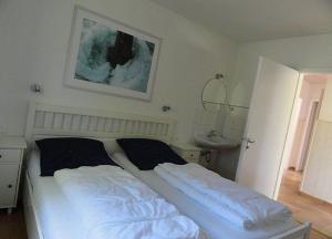 ネッセルヴァンクにあるFerienhaus Dachspfad im Feriendorf Reichenbach 5のベッドルーム(ベッド1台、シンク付) +6枚の写真