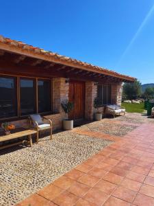 a patio of a house with benches and a porch at Villa con piscina, campo fútbol y pádel in Mas dʼen Rieres +18 photos