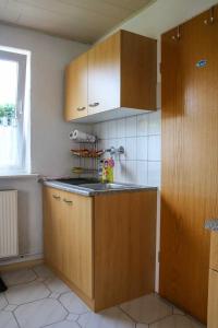 a kitchen with wooden cabinets and a counter top at Ferienwohnung Marie-Luise in Güstrow