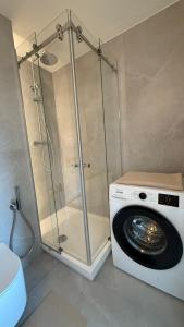a shower and a washing machine in a bathroom at Algirdo Sunlight Studio in Vilnius +29 photos