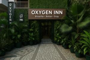 a sign for an entrance to a hotel with plants at Oxygen Inn-Couple Friendly-Noida Sector20 in Noida