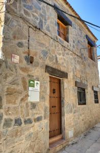 an old stone building with a wooden door at Casa Abuelo Lorenzo in Enguídanos
