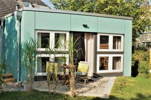 une maison bleue avec deux chaises devant dans l'établissement Susanne Hendus, à Neustadt in Holstein 6 autres photos