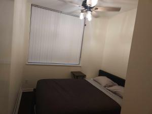 une chambre avec un lit et un ventilateur de plafond dans l'établissement Central Townhouse Richards Street, à Vancouver