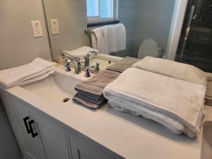 La salle de bains est pourvue d'un lavabo, de serviettes et d'un miroir. dans l'établissement Central Townhouse Richards Street, à Vancouver