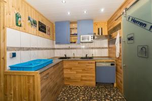 LütowUrlaub im Wohnwagen mitten im Wald的带木质橱柜和蓝色水槽的小厨房