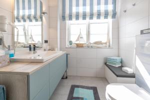 baño con lavabo, aseo y ventanas en Altes Postamt, Zeppelinstrasse, Binz, 18609, en Binz
