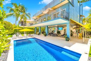an exterior view of a house with a swimming pool at Waterfront Covered alfresco lounge Heated Pool Anchor Key in Islamorada