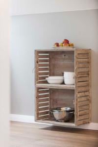 Un estante de madera con cuencos y manzanas encima. en "Villa Minerva" Ferienwohnung 09, en Kühlungsborn