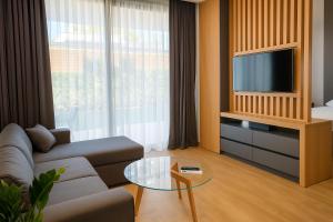 a living room with a couch and a tv at Rosemarine Villas in Durrës