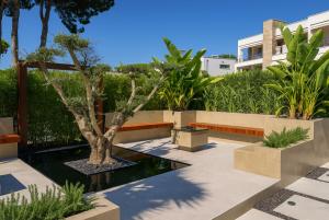 a courtyard with a tree and a pond at Rosemarine Villas in Durrës